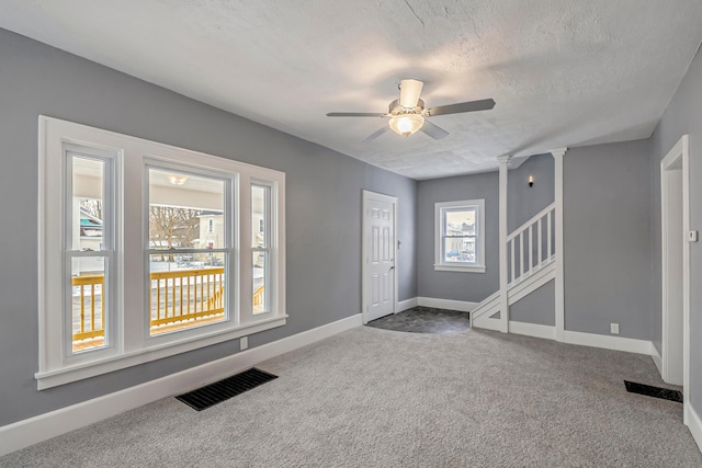 foyer entrance featuring carpet flooring, a textured ceiling, and ceiling fan