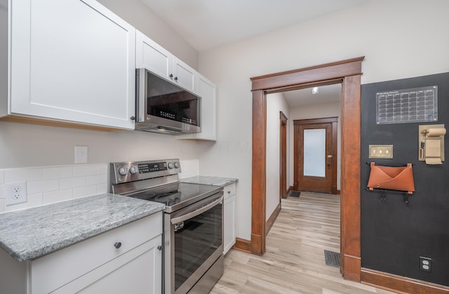 kitchen featuring white cabinets, light stone countertops, stainless steel appliances, and light hardwood / wood-style flooring