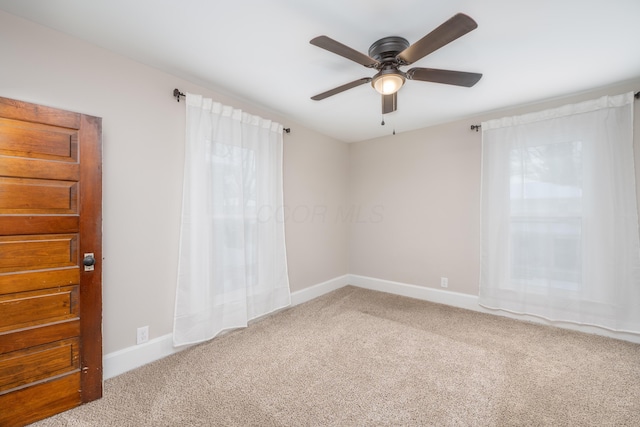 spare room with ceiling fan and carpet