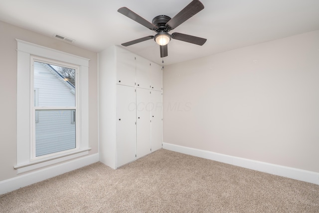 unfurnished bedroom with ceiling fan, light colored carpet, and a closet