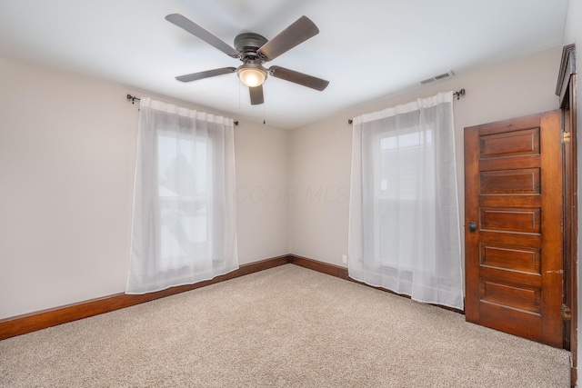 unfurnished room with ceiling fan, a wealth of natural light, and carpet flooring