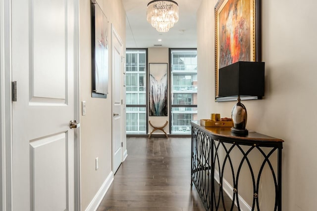 hallway featuring dark hardwood / wood-style flooring and a chandelier