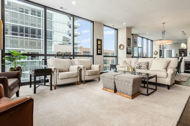 living room featuring expansive windows, beverage cooler, and a notable chandelier