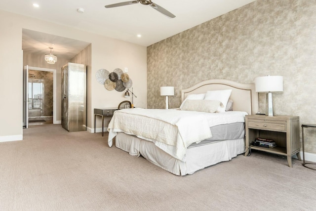 bedroom featuring ceiling fan with notable chandelier, carpet floors, and ensuite bathroom