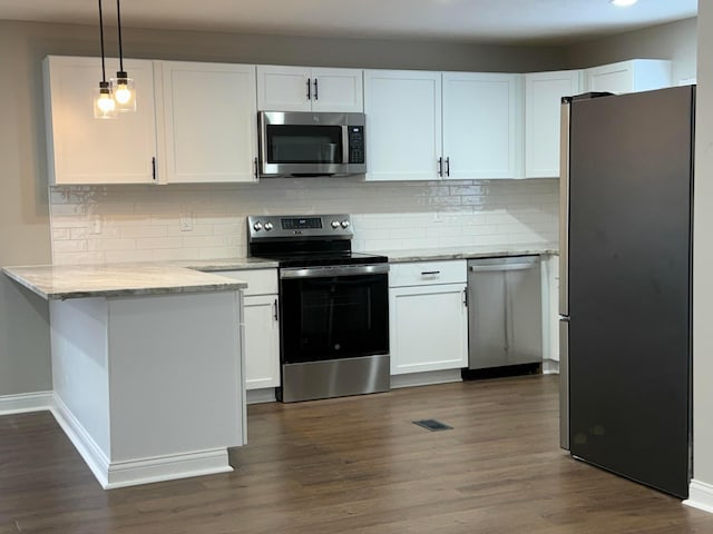 kitchen with light stone countertops, white cabinetry, pendant lighting, dark wood-type flooring, and stainless steel appliances