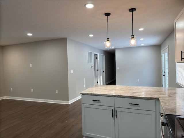 kitchen with dark wood-type flooring, hanging light fixtures, and white cabinets