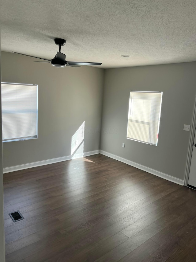 spare room featuring a textured ceiling, dark hardwood / wood-style floors, and ceiling fan