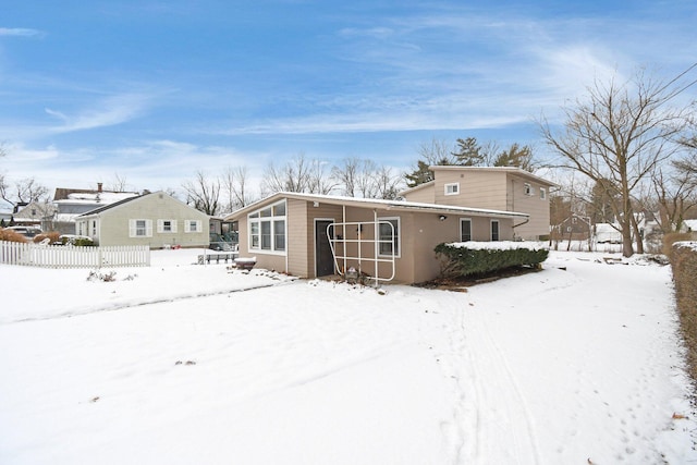 view of snow covered back of property