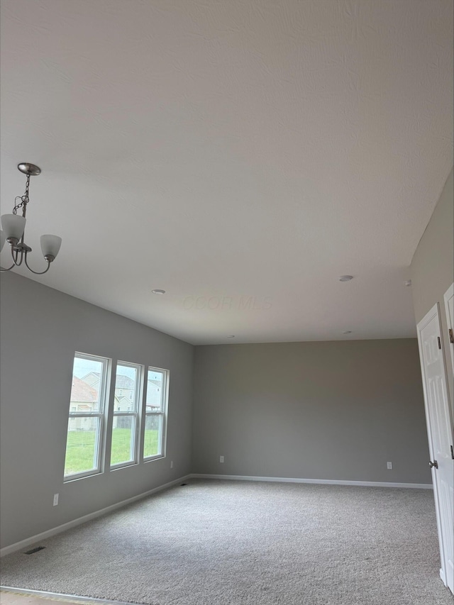 empty room featuring baseboards and light colored carpet