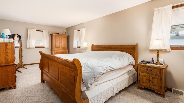 bedroom featuring baseboards, visible vents, and light colored carpet