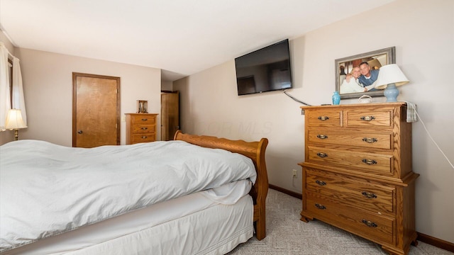 bedroom featuring baseboards and light colored carpet