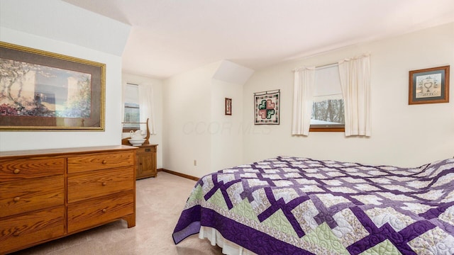 bedroom featuring light colored carpet and baseboards