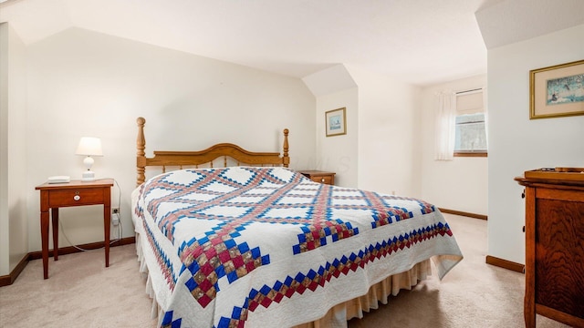 carpeted bedroom featuring lofted ceiling and baseboards