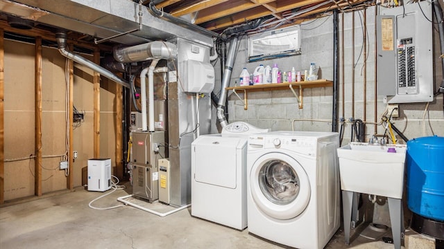 laundry room with a sink, laundry area, washing machine and clothes dryer, and electric panel