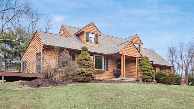 view of front of house with a shingled roof and a front yard