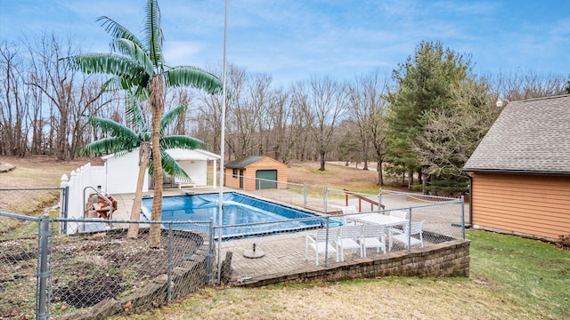 view of pool featuring an outbuilding, a yard, fence, and a fenced in pool