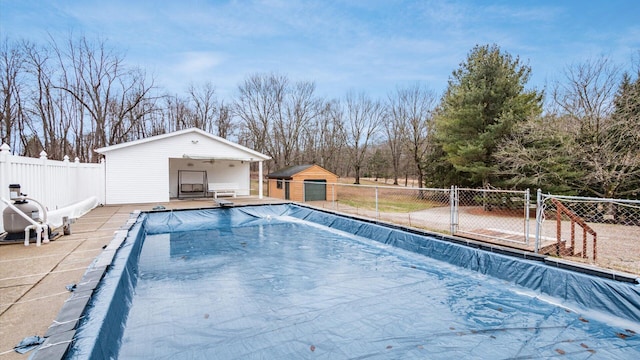 view of pool featuring fence, a fenced in pool, and an outdoor structure