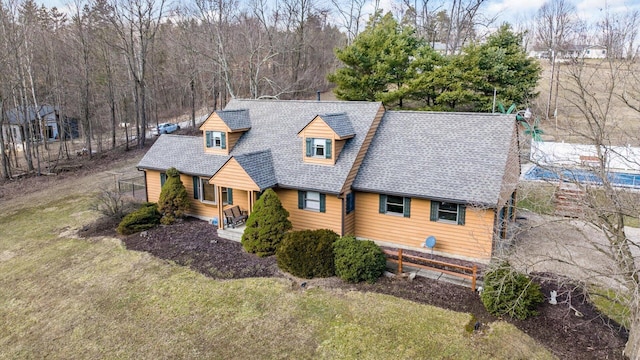 view of front of home featuring a shingled roof and a front lawn