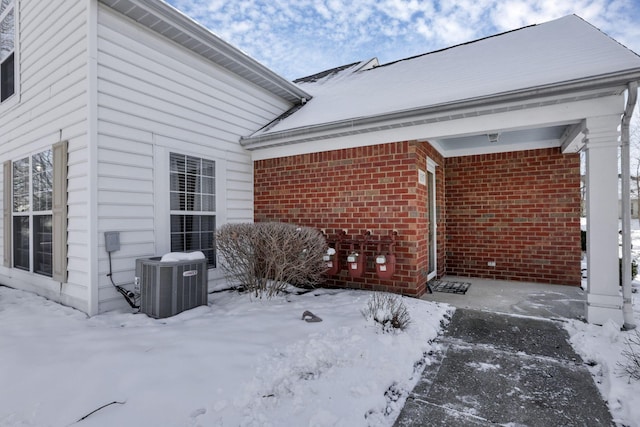 snow covered patio featuring central AC unit