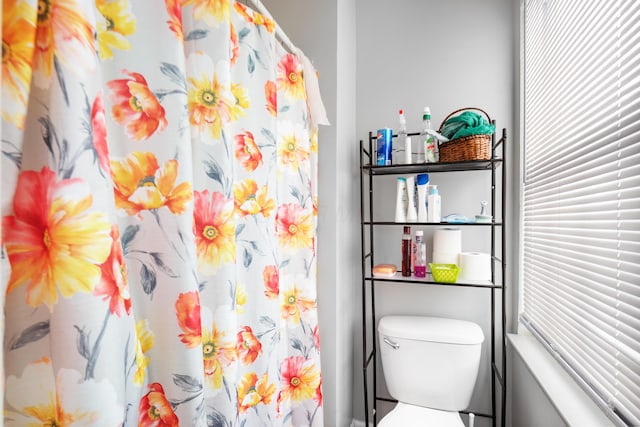 bathroom with a shower with curtain and toilet