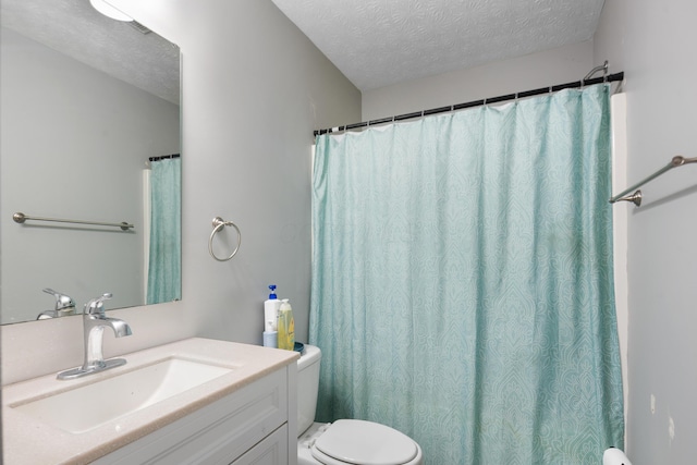 bathroom with vanity, toilet, and a textured ceiling