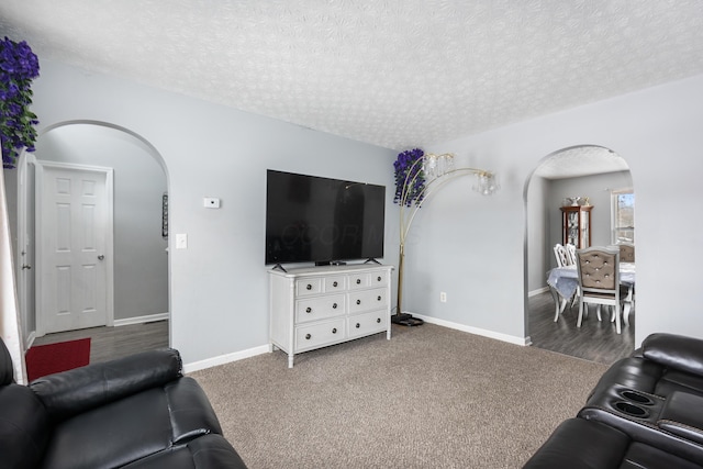 living room with dark colored carpet and a textured ceiling