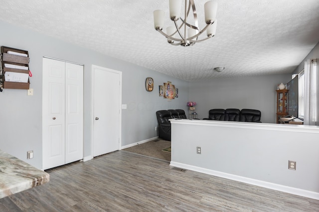 interior space with hardwood / wood-style floors, a notable chandelier, and a textured ceiling