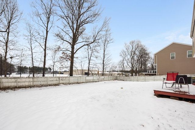 yard layered in snow with a deck