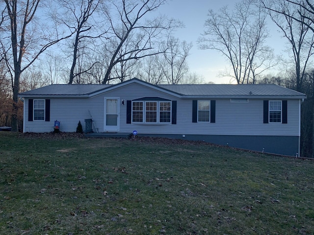 view of front of property with metal roof and a front lawn