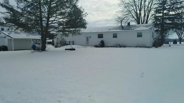 snow covered property with an outdoor structure