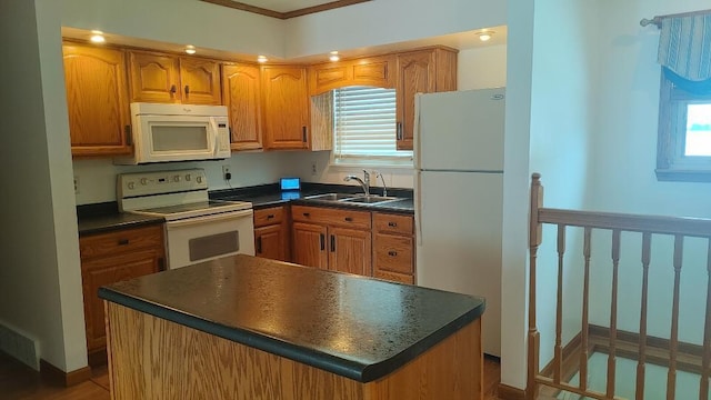 kitchen with sink, a kitchen island, and white appliances