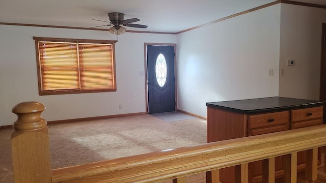 carpeted entryway featuring ceiling fan and crown molding