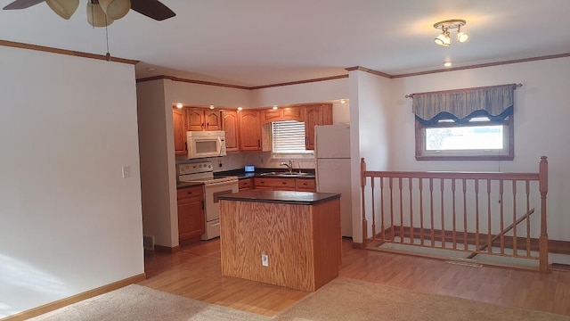 kitchen featuring white appliances, a center island, plenty of natural light, and light hardwood / wood-style floors