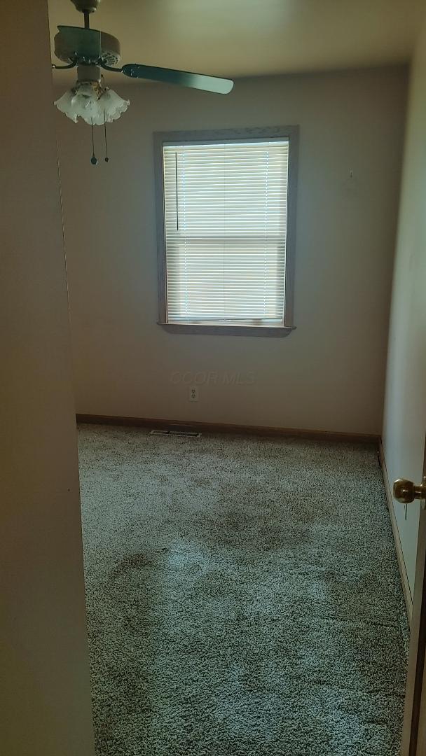 carpeted empty room with ceiling fan