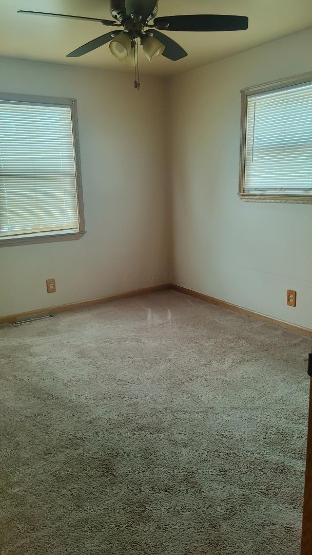 carpeted empty room with ceiling fan