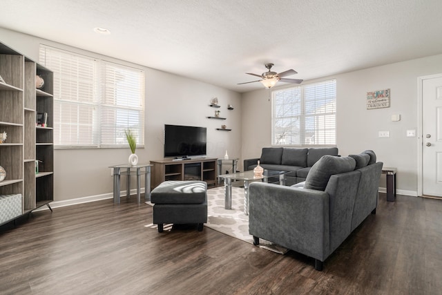 living room featuring ceiling fan, a textured ceiling, and dark hardwood / wood-style flooring