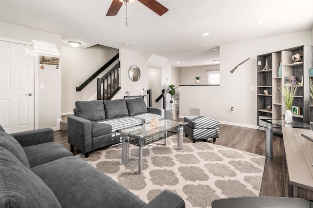 living room featuring ceiling fan and dark wood-type flooring