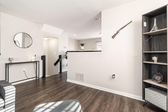 unfurnished room featuring a textured ceiling and dark hardwood / wood-style flooring