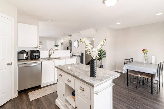 kitchen with a center island, stainless steel dishwasher, white cabinets, sink, and dark hardwood / wood-style floors