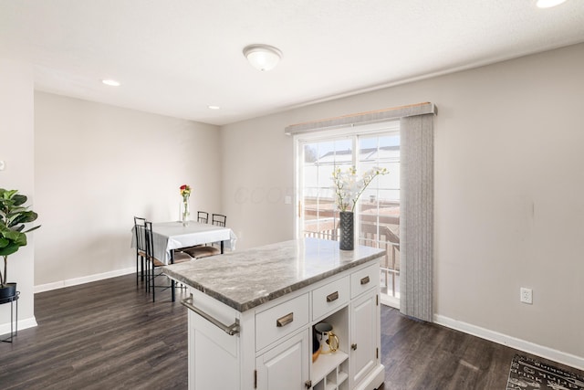 kitchen with white cabinets, a center island, and dark hardwood / wood-style floors