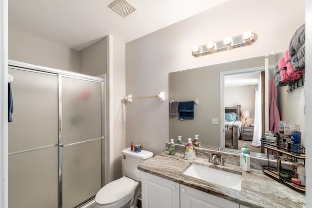 bathroom featuring a shower with shower door, a textured ceiling, toilet, and vanity