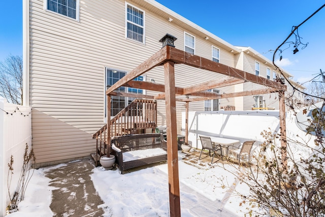 snow covered patio featuring a pergola