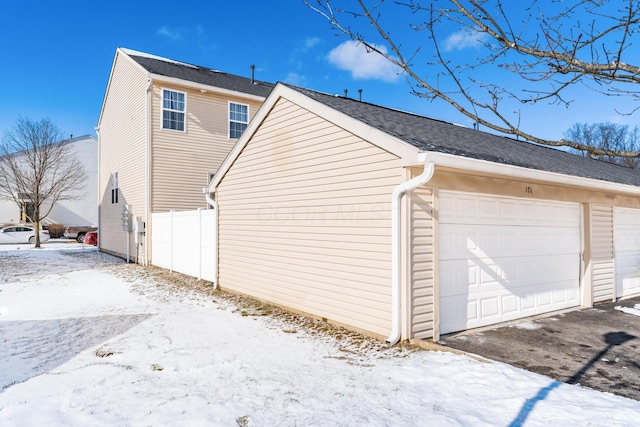 snow covered property featuring a garage