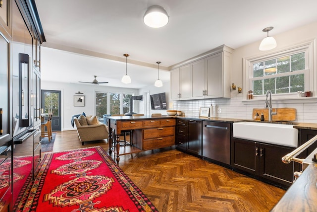 kitchen with dishwasher, ceiling fan, pendant lighting, sink, and backsplash