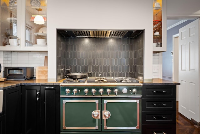 kitchen featuring range with two ovens, ornamental molding, and tasteful backsplash