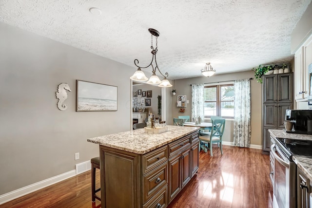 kitchen featuring a kitchen island, electric stove, hanging light fixtures, and dark wood-type flooring