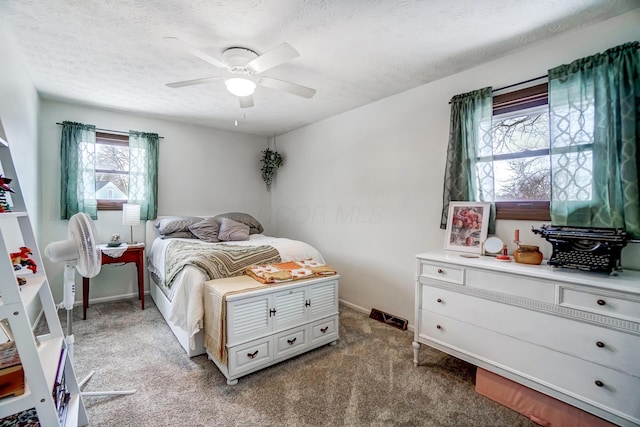 carpeted bedroom featuring a textured ceiling and ceiling fan