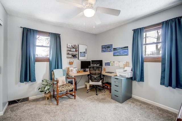 home office featuring a healthy amount of sunlight, a textured ceiling, ceiling fan, and carpet flooring