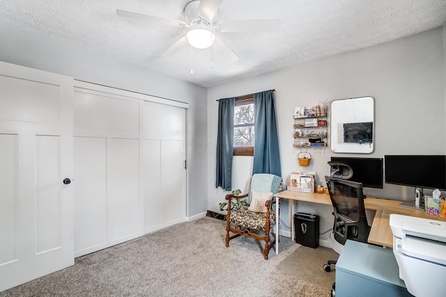 office space featuring a textured ceiling, ceiling fan, and light carpet