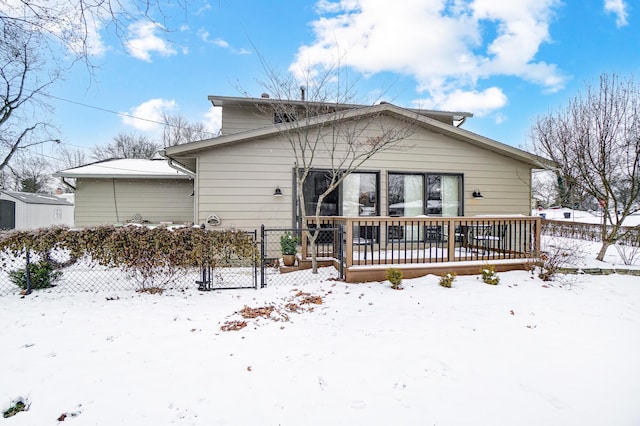 snow covered house featuring a deck